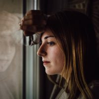 woman leaning on glass window